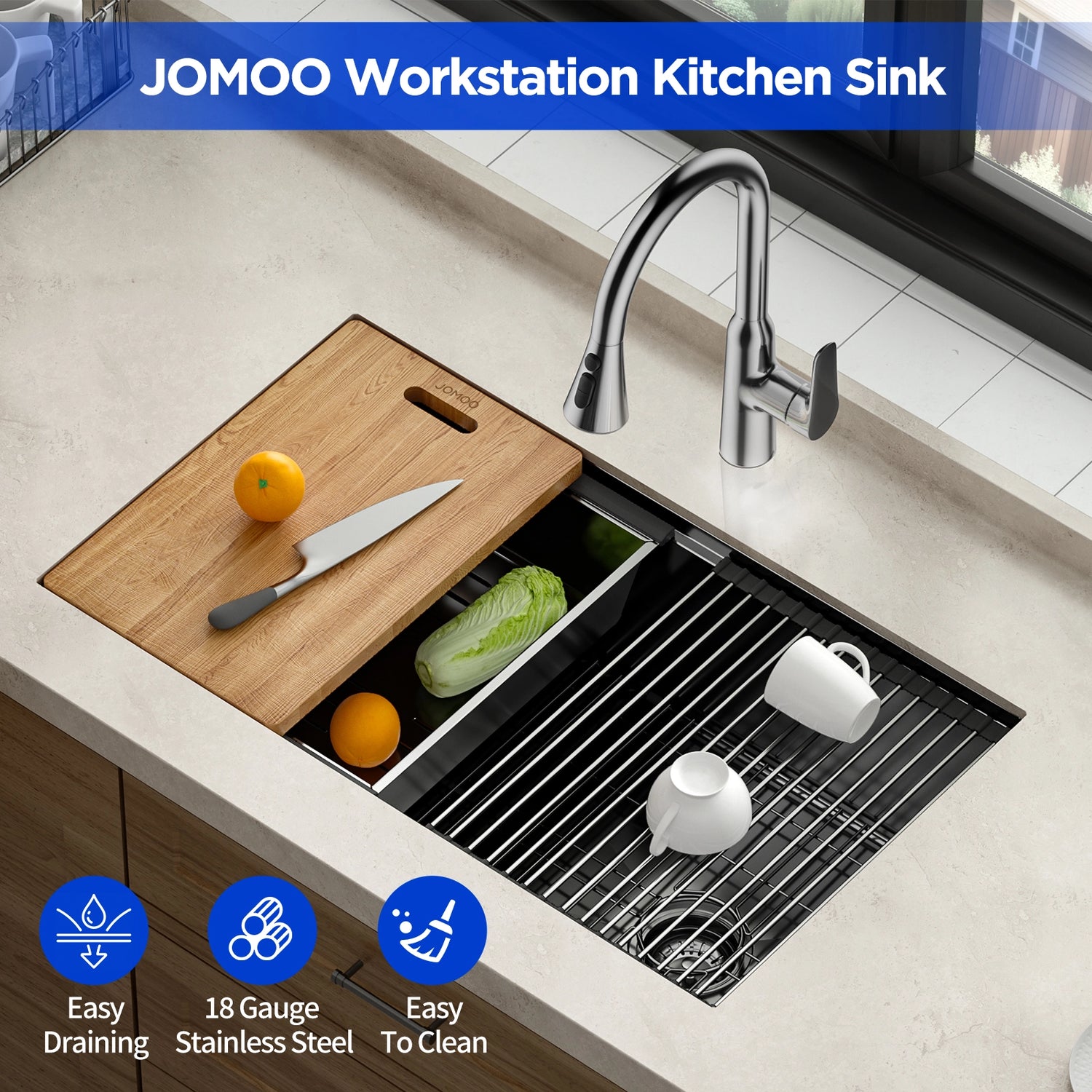 Shows a JOMOO workstation kitchen sink with a bamboo cutting board placed on top, holding a knife and an orange. The sink features a sleek design with the JOMOO logo displayed at the top and highlights like "Easy Draining", "18 Gauge Stainless Steel", and "Easy To Clean" at the bottom.