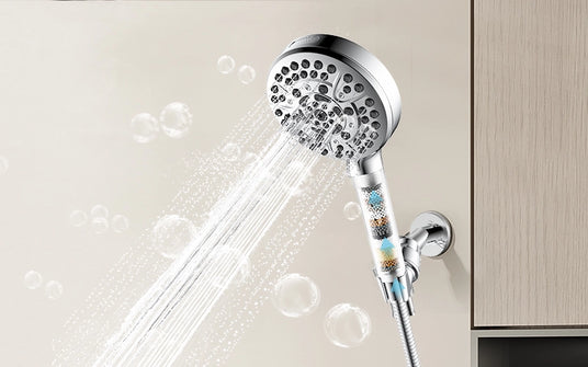 A polished chrome JOMOO handheld shower with three spray modes rests on a sleek wall bracket, set against glossy white tiles.