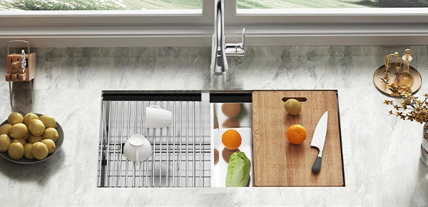 A brushed-stainless JOMOO single-bowl sink, deep and seamless, sits flush in a light-gray countertop beneath a minimalist gooseneck faucet.