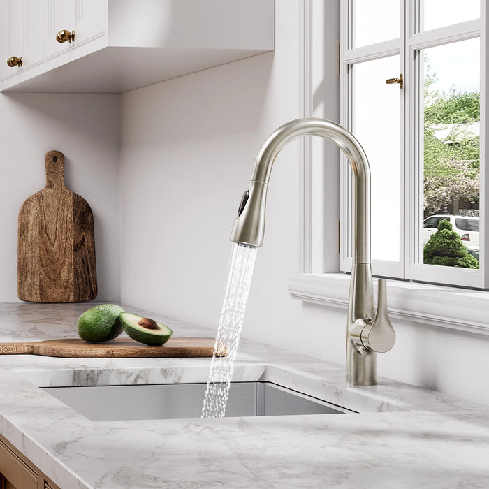 A brushed-nickel JOMOO pull-down faucet arcs gracefully above a stainless sink, its single handle and retractable spray head gleaming under soft kitchen lighting.